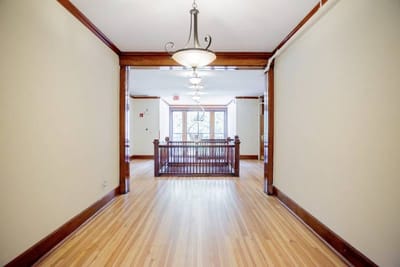Interior hallway with wooden flooring and lights.