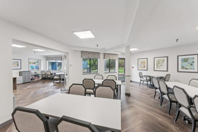 Common area with tables and chairs for activities.