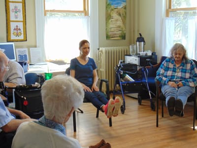 Residents participating in a seated exercise class.