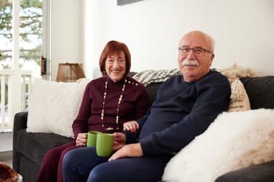 Elderly couple sitting together on a couch