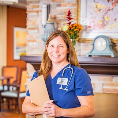 Nurse smiling in a cozy interior space.