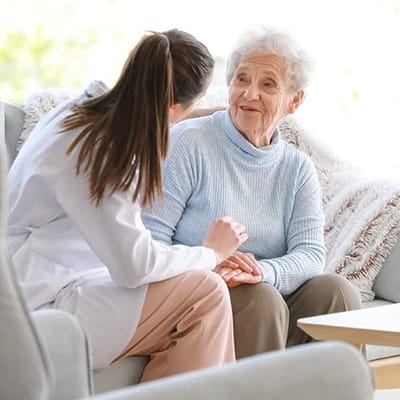 Nurse interacting with an elderly resident indoors.