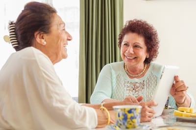 Two elderly women enjoying a conversation at a table.