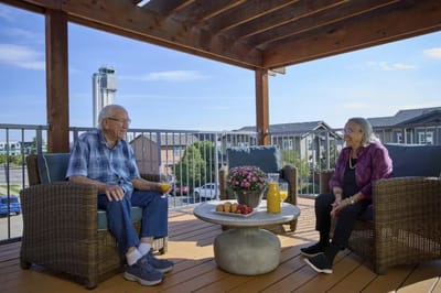 Two residents enjoying a conversation on a balcony.