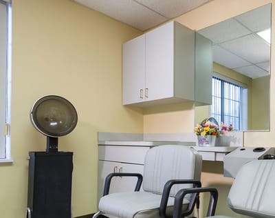 Hair salon area with styling chairs and mirror