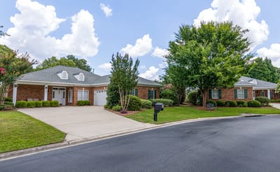 Exterior view of the retirement community buildings with gardens