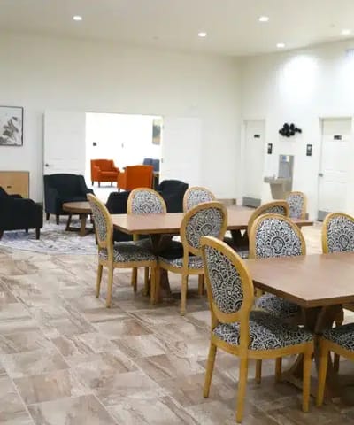 A bright common area with seating and tables