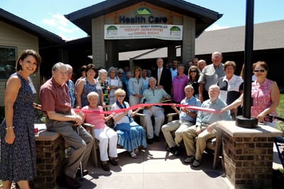 Residents and staff celebrating a grand opening outside the facility