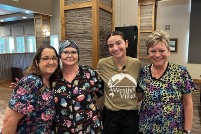 Staff and residents smiling together in a shared space