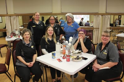 Staff members posing together in a dining area