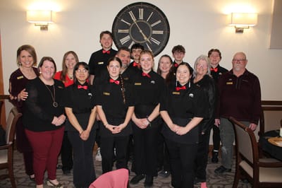 Staff members posing together in a dining area
