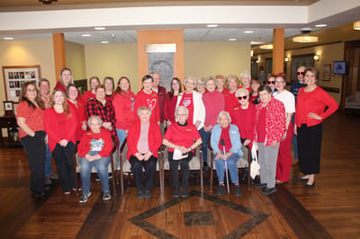Residents and staff dressed in red poses together