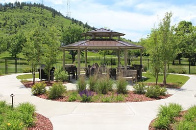 Outdoor gazebo surrounded by landscaping and garden pathways