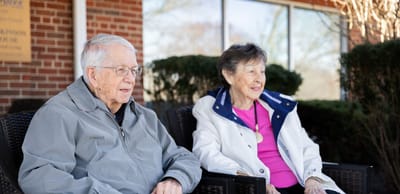 Two residents sitting outside in a serene environment