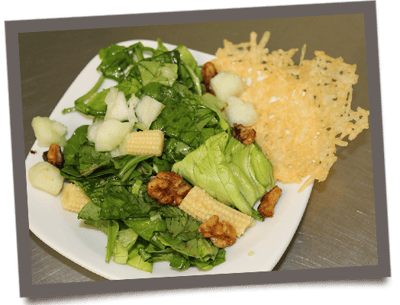 A fresh salad with spinach, corn, and nuts on a plate