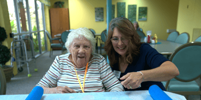 A resident and staff member smiling in a common area