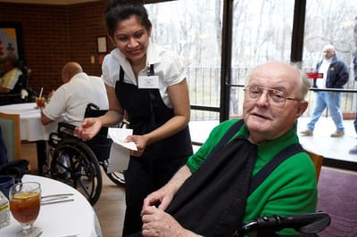 Staff serving a meal in the dining room