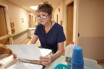 Staff member reviewing paperwork in a hallway