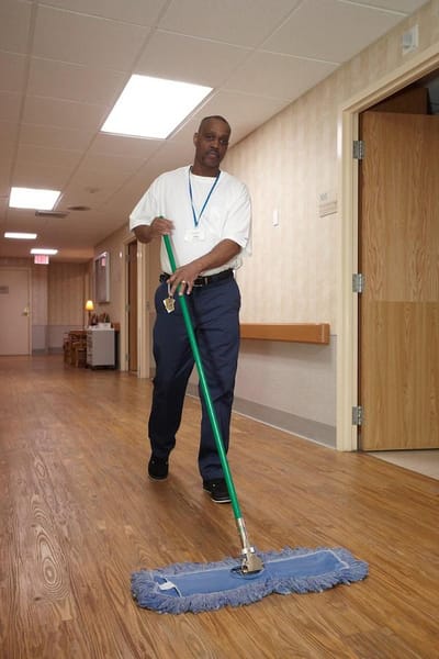 Staff member cleaning a corridor in the facility