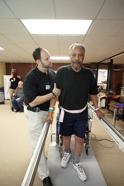 A resident receiving assistance during therapy in a facility