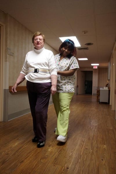 Staff assisting a resident in the hallway