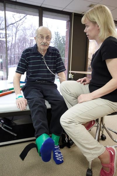 Therapist assisting a resident with rehabilitation exercises