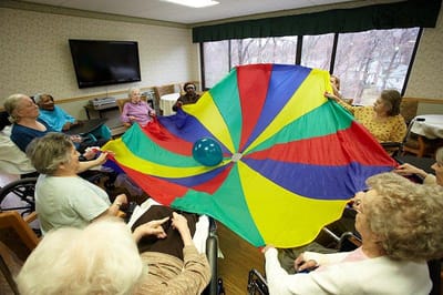 Residents participating in a group activity with a colorful parachute