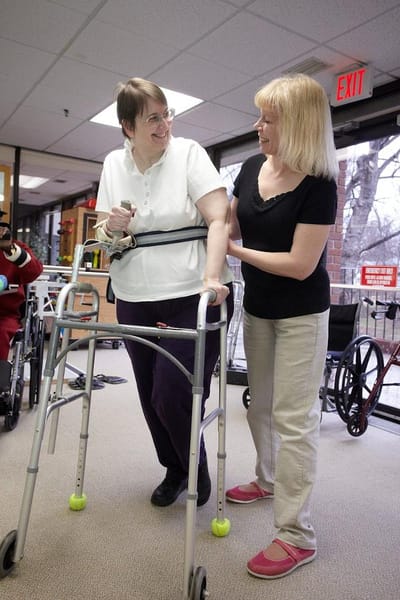 Staff assisting a resident with a walker indoors