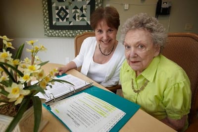 Two residents smiling at a table with documents