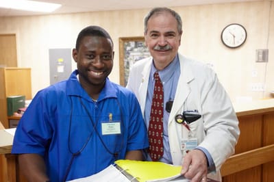 Two staff members smiling at a reception desk