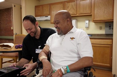 Staff assisting a resident in a facility interior