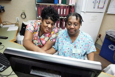 Two staff members working together at a computer
