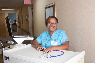 Staff member smiling at a reception desk in the facility