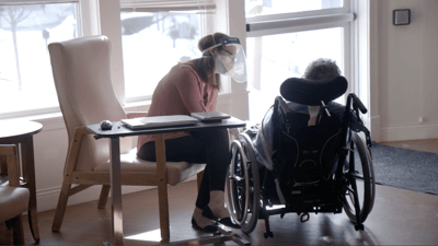 Staff member interacting with resident in wheelchair