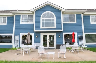 Exterior view of a nursing home building with outdoor seating.