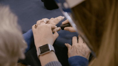 Two pairs of hands engaged in a gentle activity.