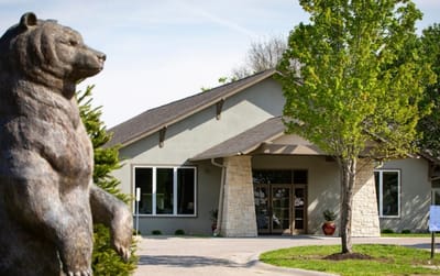 Building exterior with bear statue and trees