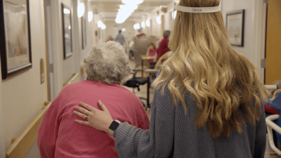 Staff member assisting a resident in the hallway