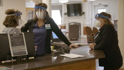 Staff members interacting at the reception desk.