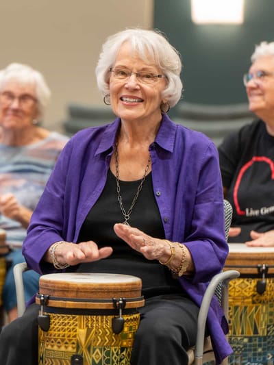 Resident participating in a drumming activity.