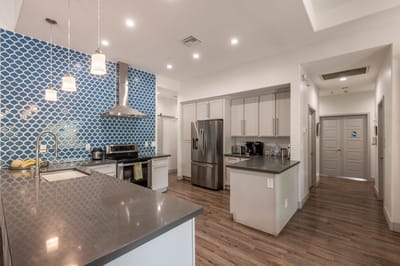 Modern kitchen interior with a blue tile backsplash.