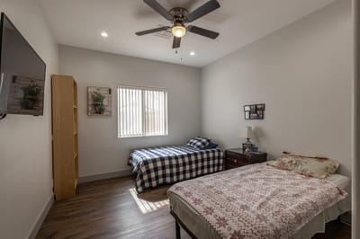 A cozy resident room with two beds and natural light.