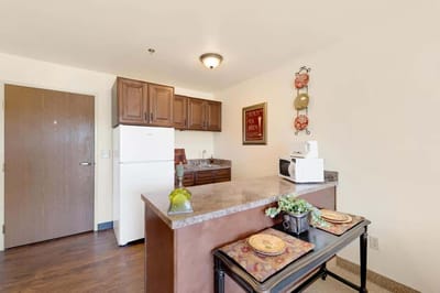 Bright kitchen area with appliances and dining setup.