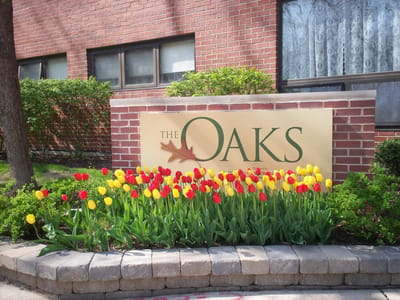 Sign of The Oaks with blooming tulips