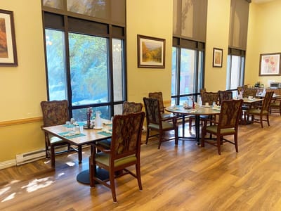 Well-set dining area with tables and chairs.