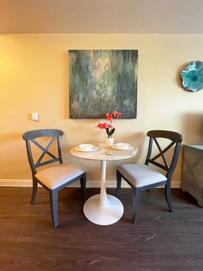 A cozy table setting with chairs and flowers.