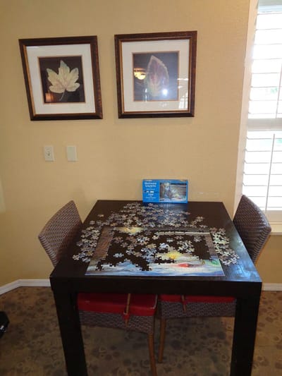 Puzzle on a dining table with framed art.