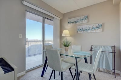 Cozy interior with glass table and access to outdoor balcony.