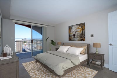 Brightly decorated resident bedroom with balcony view.