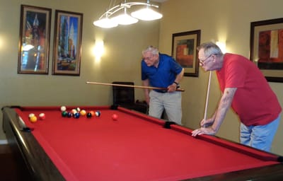 Residents enjoying a game of pool indoors.